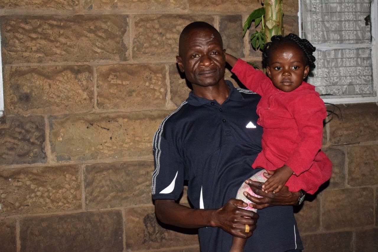 Baba Onyango holding his child